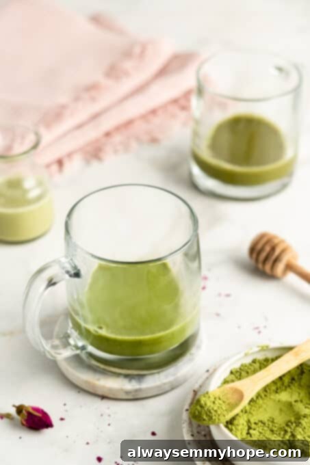 Two clear glass mugs filled with a vibrant green matcha base, waiting for the frothed milk to be added.