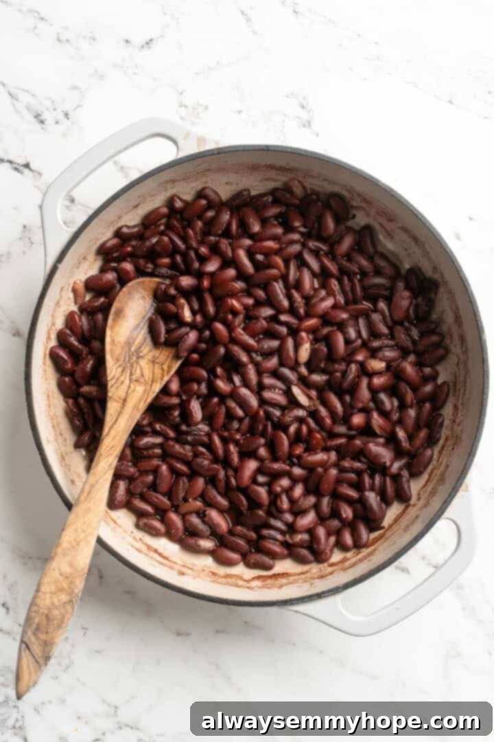 This authentic Jamaican rice and peas recipe is an easy side dish with lots of island vibes! It's packed with flavour and so simple to make. Tender, cooked kidney beans visible in a pan, ready for the next stage of the recipe.