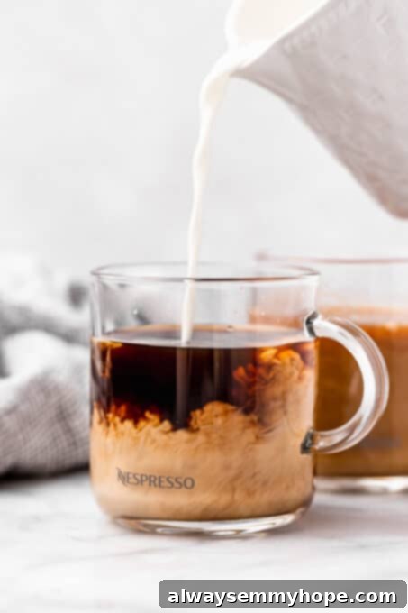 Vegan heavy cream being poured into glass coffee mug