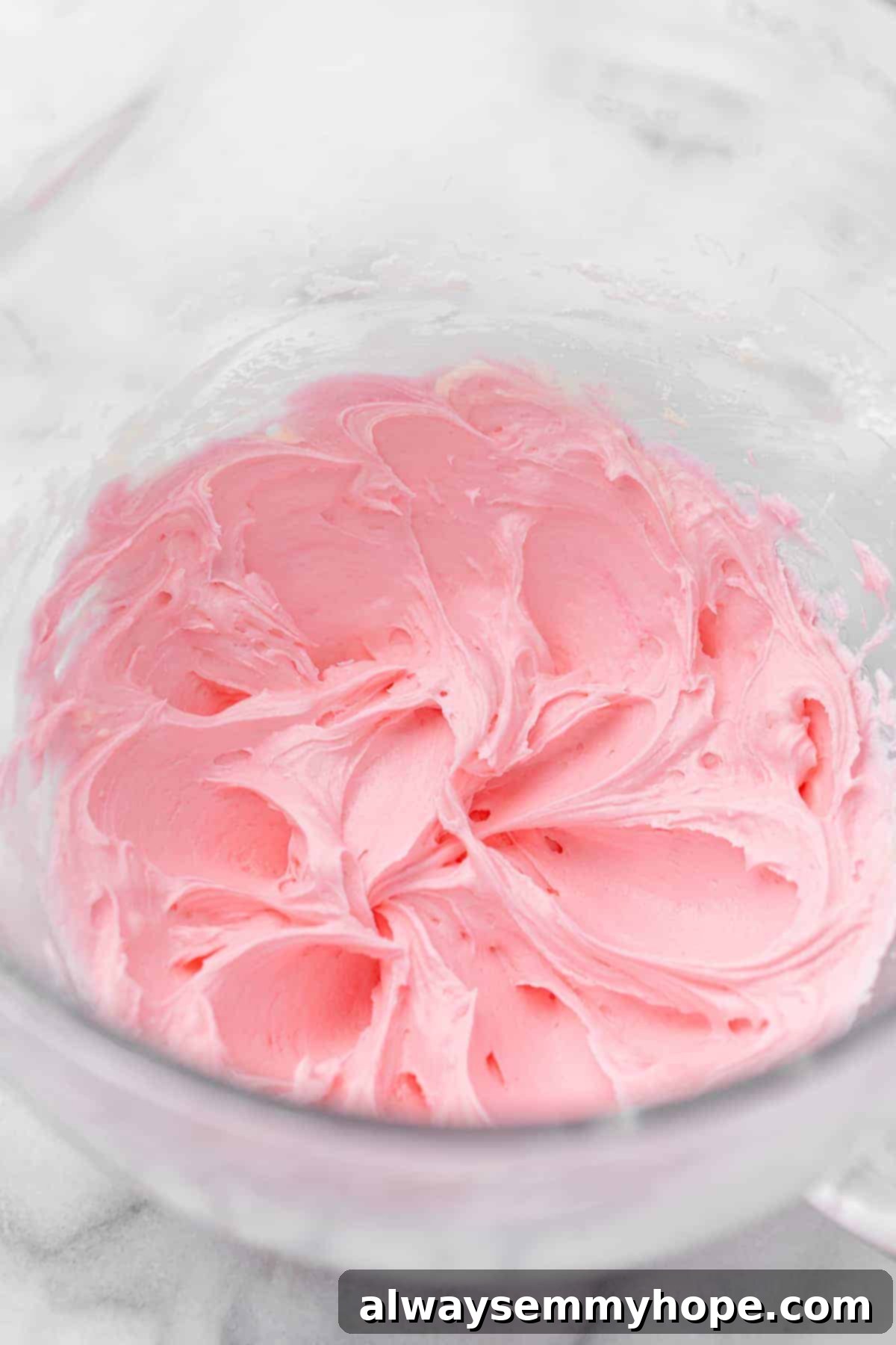 These vegan frosted sugar cookie bars have all the flavor of a classic sugar cookie, without the rolling and cutting, or the dairy and eggs! Pink frosting in mixing bowl