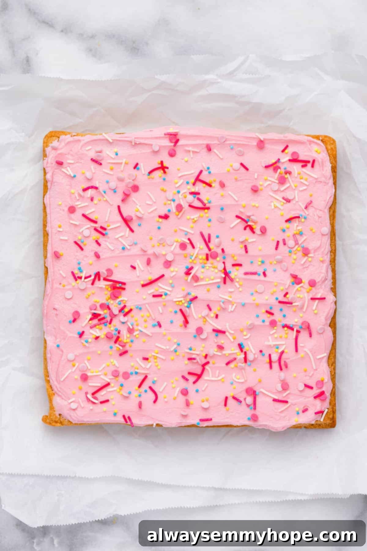 These vegan frosted sugar cookie bars have all the flavor of a classic sugar cookie, without the rolling and cutting, or the dairy and eggs! Overhead view of sugar cookie bars before cutting