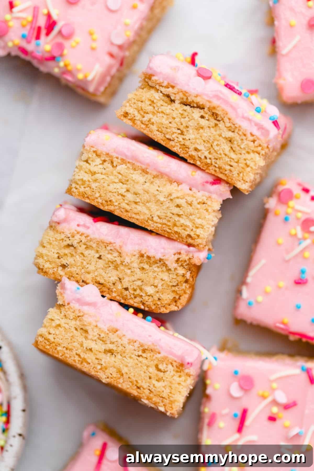 These vegan frosted sugar cookie bars have all the flavor of a classic sugar cookie, without the rolling and cutting, or the dairy and eggs! Stack of sugar cookie bars on their sides