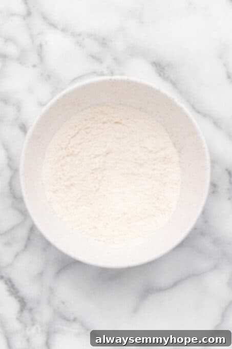 These vegan frosted sugar cookie bars have all the flavor of a classic sugar cookie, without the rolling and cutting, or the dairy and eggs! Overhead view of dry sugar cookie bar ingredients in mixing bowl