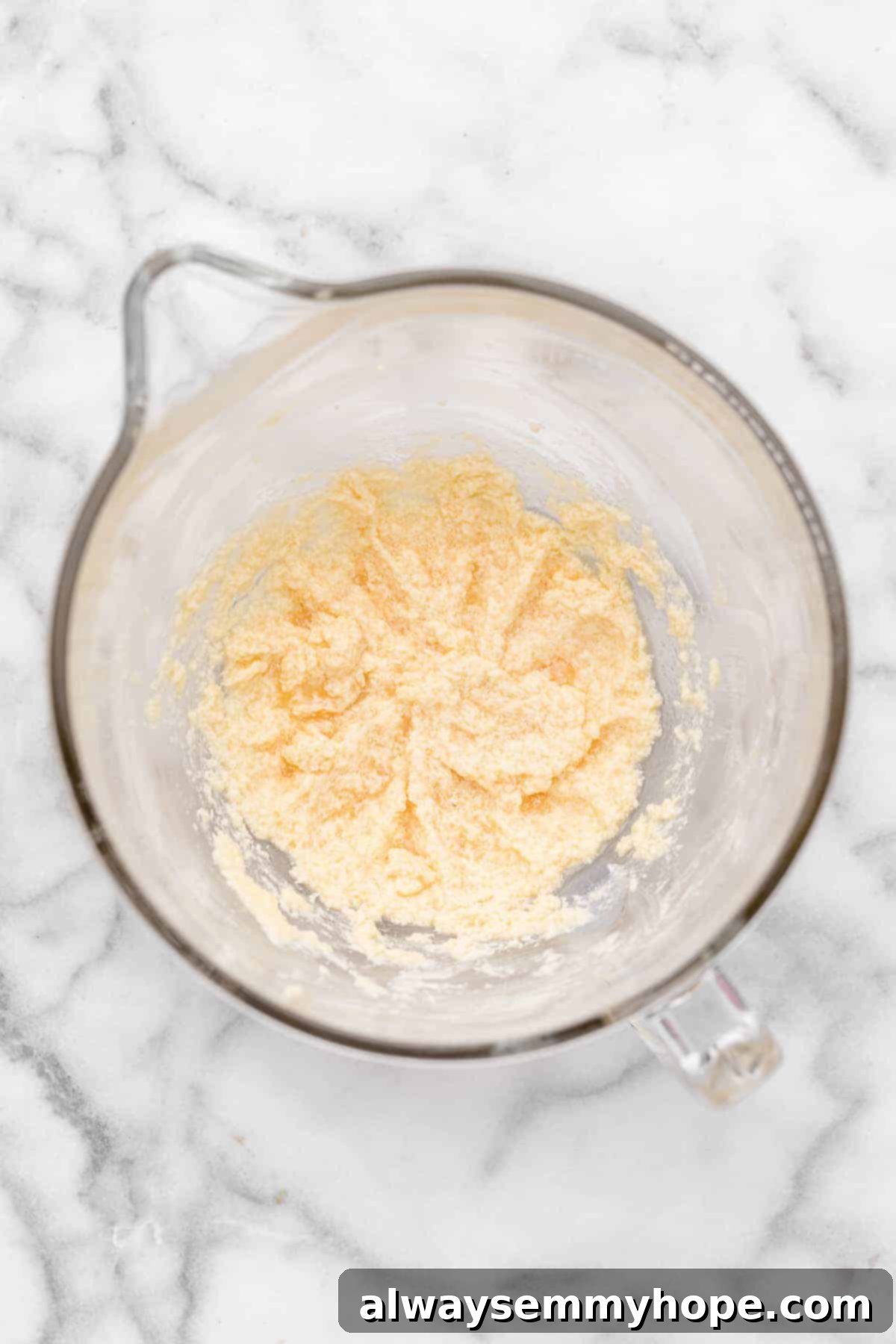 These vegan frosted sugar cookie bars have all the flavor of a classic sugar cookie, without the rolling and cutting, or the dairy and eggs! Overhead view of wet sugar cookie ingredients in glass mixing bowl