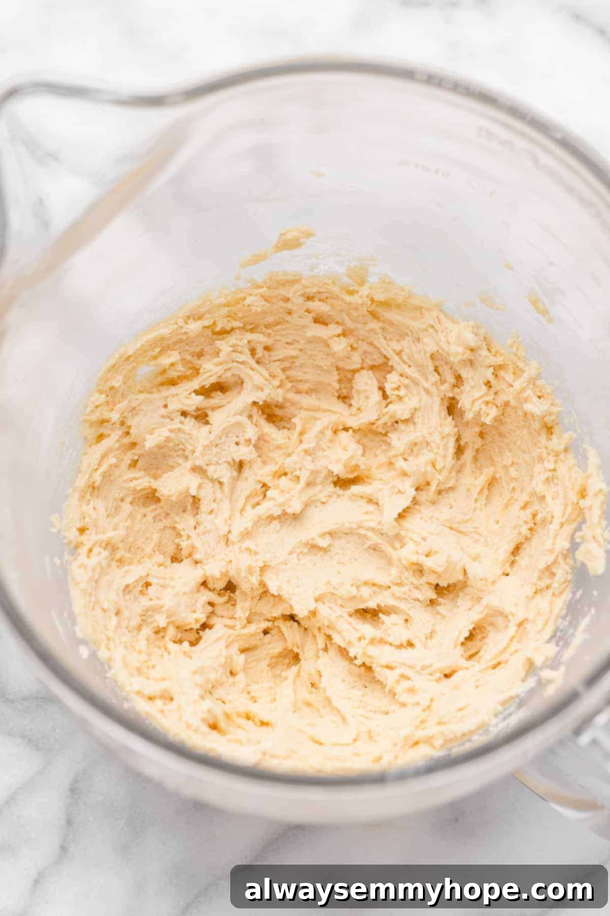 These vegan frosted sugar cookie bars have all the flavor of a classic sugar cookie, without the rolling and cutting, or the dairy and eggs! Overhead view of sugar cookie dough in glass mixing bowl