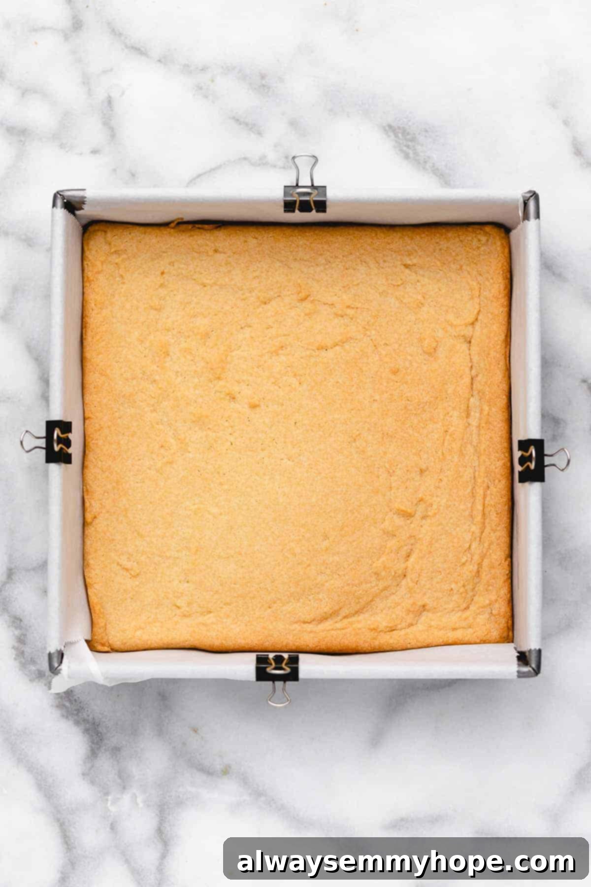 These vegan frosted sugar cookie bars have all the flavor of a classic sugar cookie, without the rolling and cutting, or the dairy and eggs! Sugar cookie bars in pan before frosting