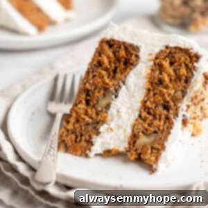 Decadent Plant-Based Carrot Cake 16 Closeup of vegan carrot cake slice on white plate with fork