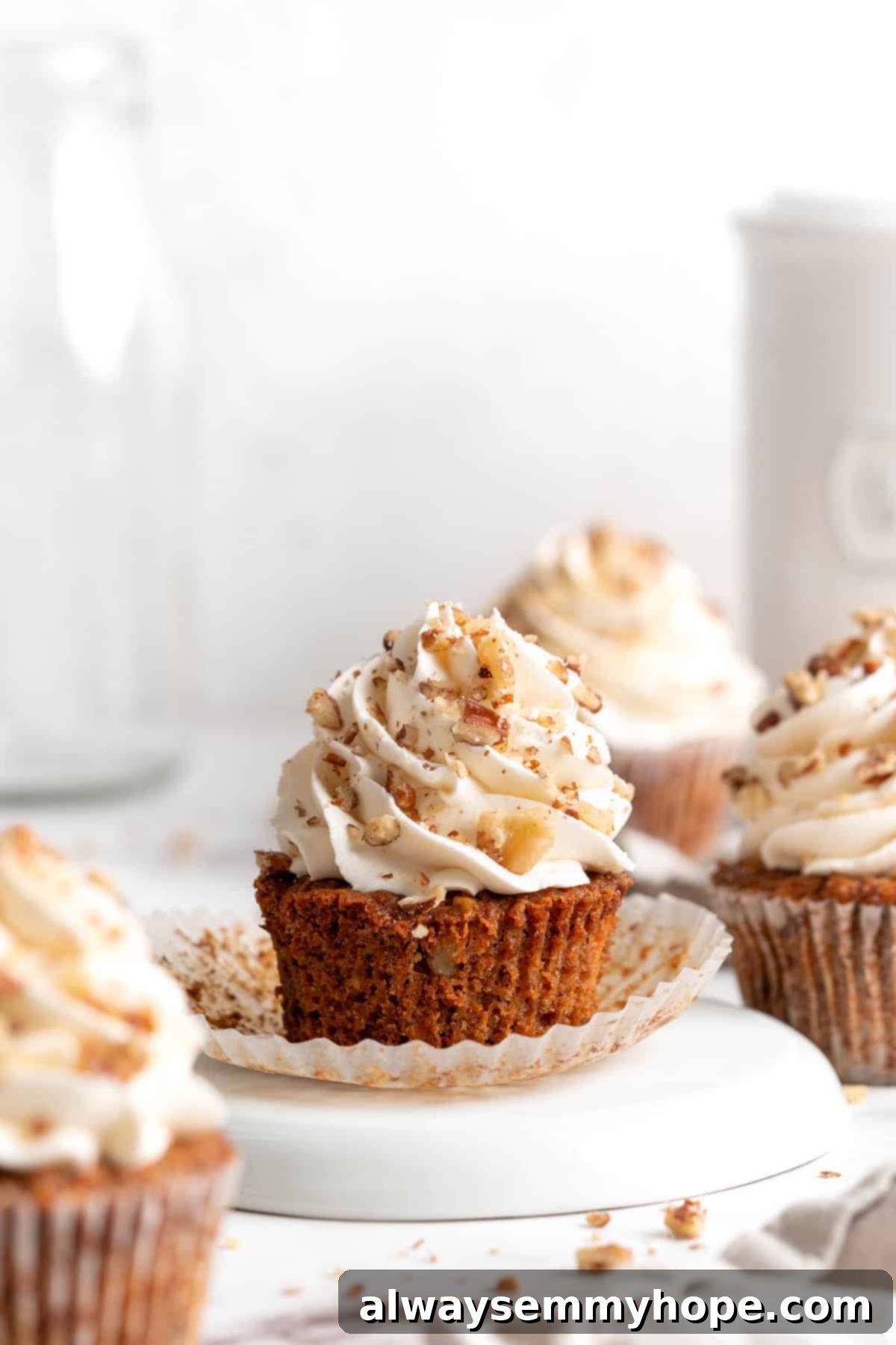 Carrot cupcake topped with vegan cream cheese frosting and walnuts
