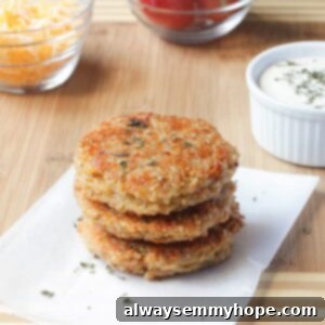 A stack of golden-brown Sun-dried Tomato and Mozzarella Quinoa Burgers on a rustic wooden board, garnished with fresh herbs, showcasing their inviting texture and rich color.