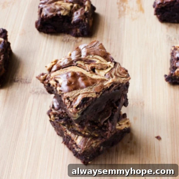 Delicious Chewy and Fudgy Peanut Butter Swirl Brownies Close-up of a stack of fudgy peanut butter swirl brownies on a wooden table, showcasing the distinct chocolate and peanut butter layers.