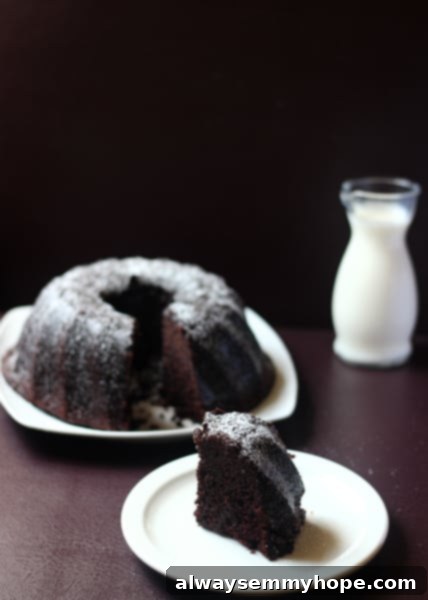 A mouth-watering slice of Guinness Chocolate Cake paired with a refreshing glass of milk, highlighting the cake's dark, rich color and soft texture.