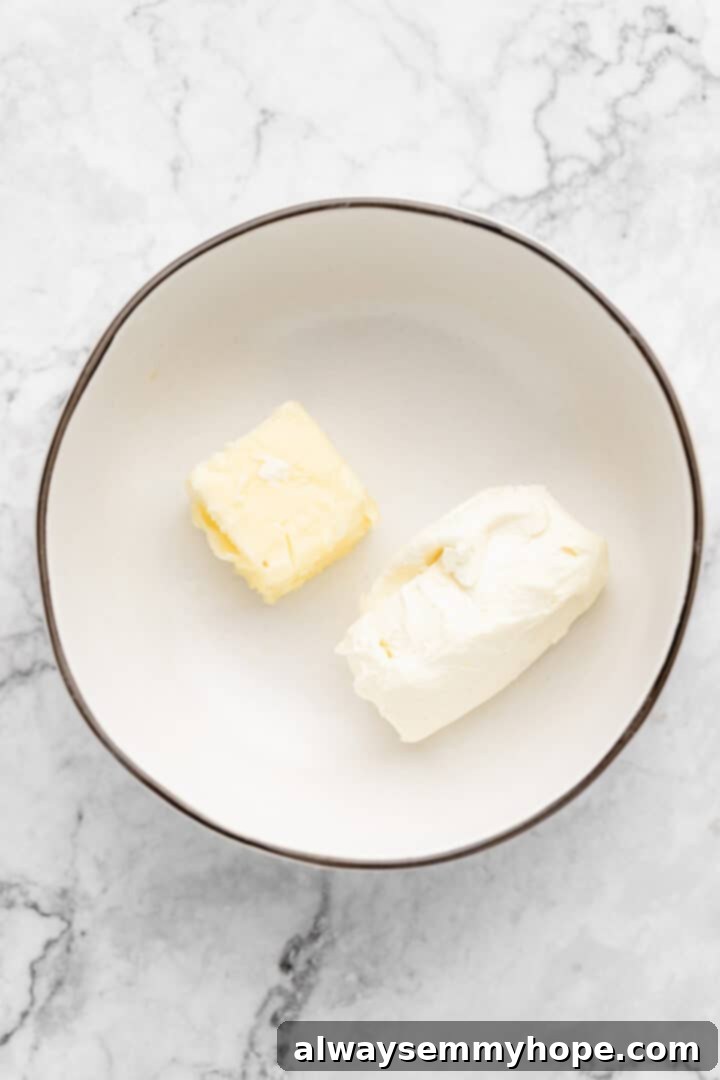 Overhead view of room temperature vegan butter and vegan cream cheese in a mixer bowl.