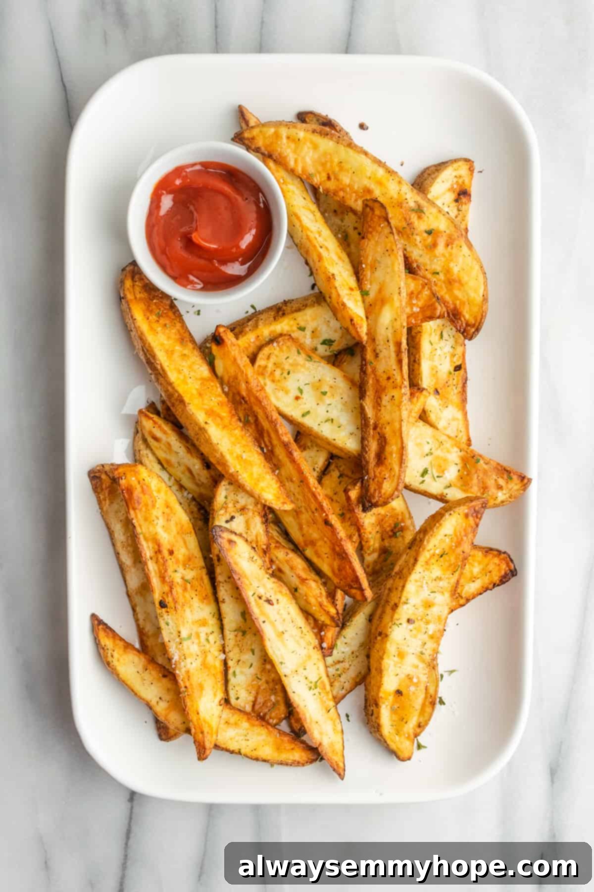 These quick and easy air fryer potato wedges are crispy on the outside, fluffy on the inside, and the perfect side for your burger. A neatly arranged plate of crispy, golden-brown air fryer potato wedges, accompanied by a small ramekin of ketchup. The presentation is simple yet appetizing, highlighting the delicious texture of the wedges.