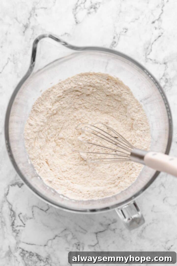 Fluffy Vegan Japanese Milk Bread 11 Overhead view of dry bread ingredients in glass mixing bowl with whisk