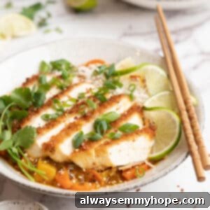 Bowl of katsu curry with tofu, garnished with cilantro, scallions, and lime slices