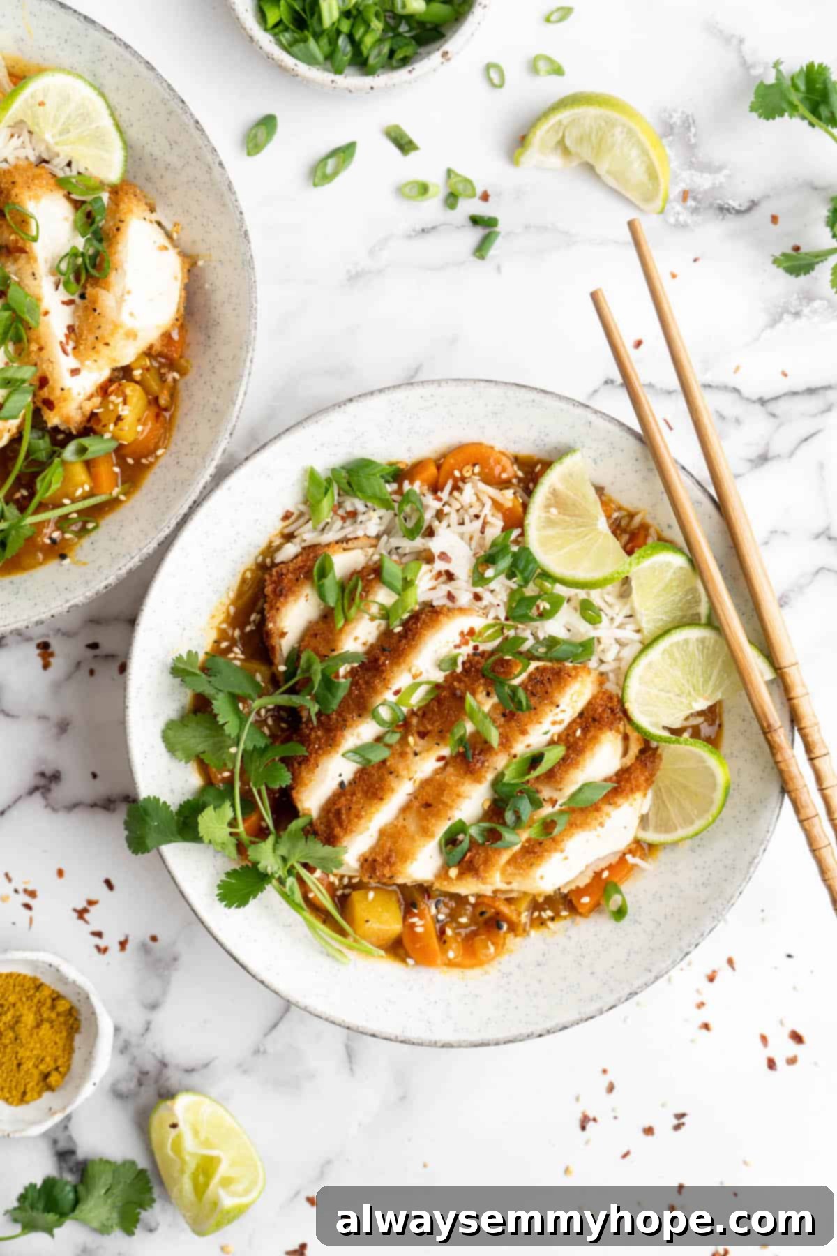 Bowl of vegan katsu curry garnished with cilantro and lime