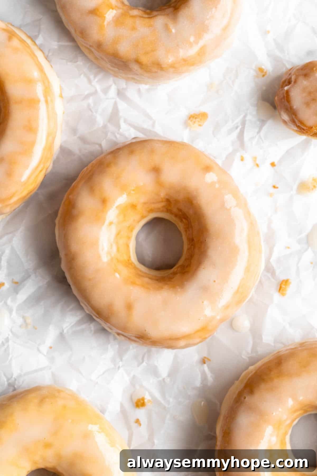 Close-up view of a freshly glazed vegan donut, showing its soft texture and glistening glaze