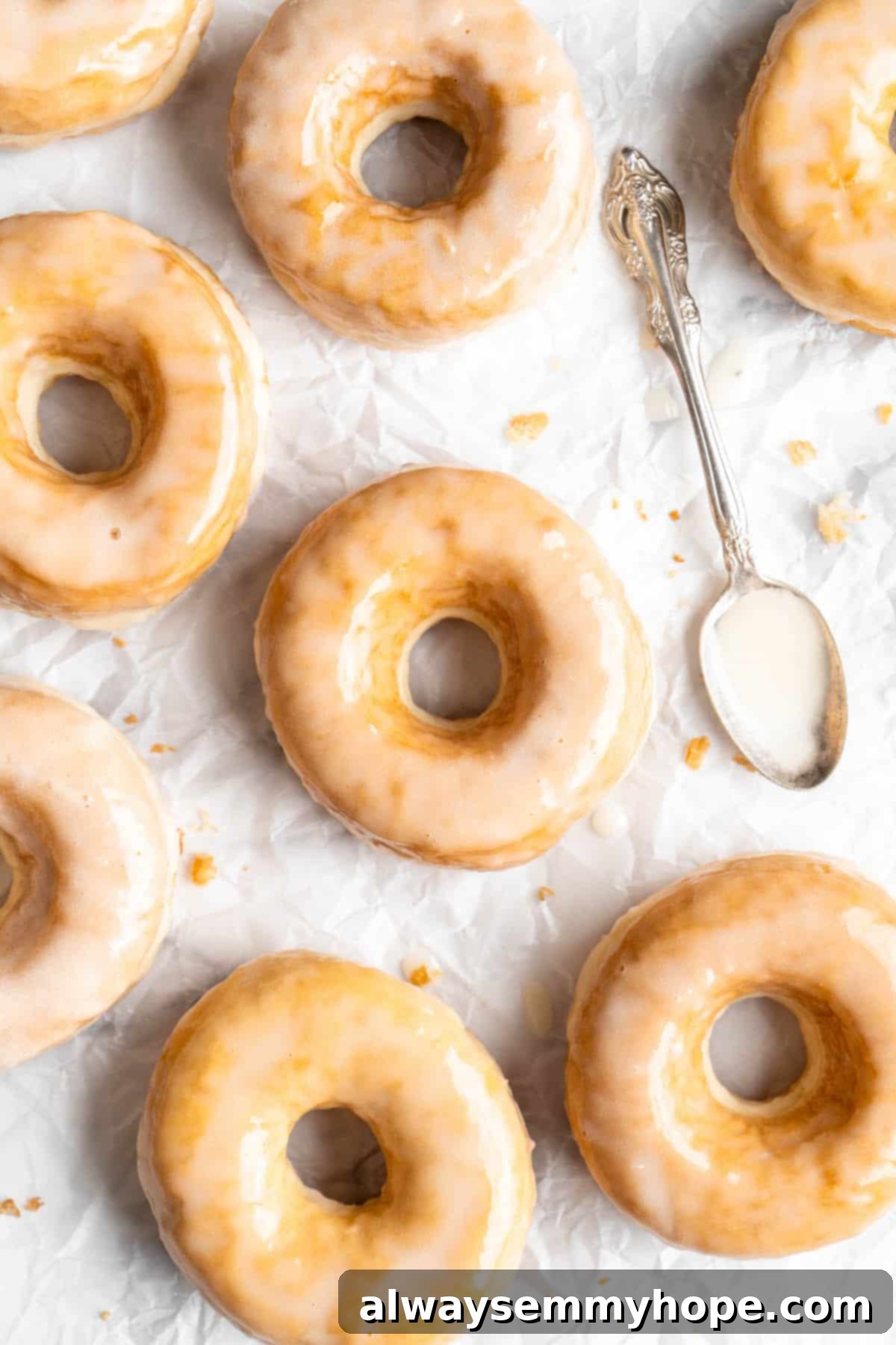 Classic vegan glazed donuts on a cooling rack with a spoonful of glaze