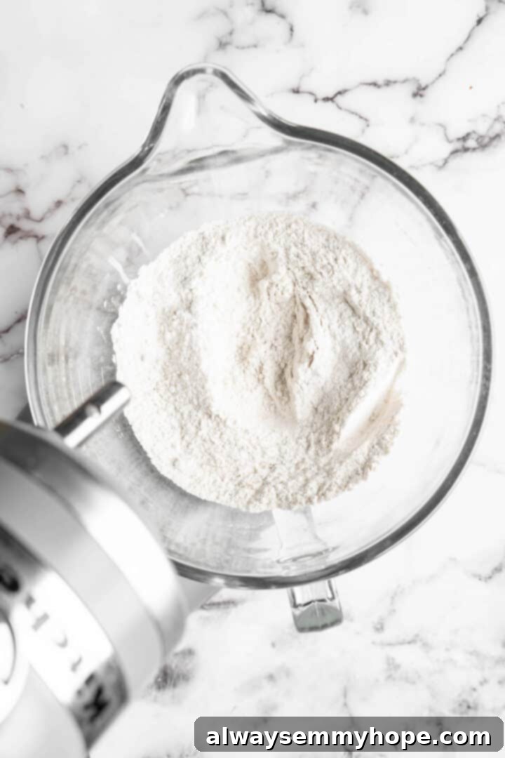 Dry ingredients for vegan donuts in a clear glass mixing bowl