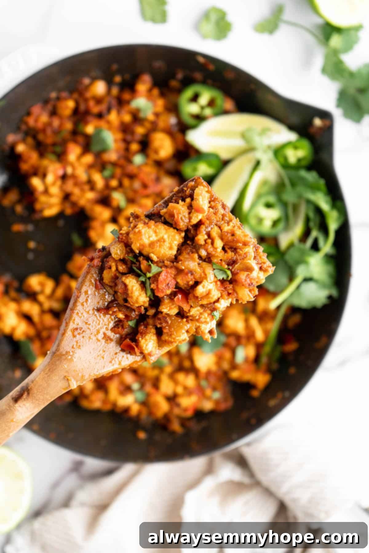 Homemade Chipotle Sofritas 3 Wooden spoon holding a scoop of sofritas over a cast iron skillet, showcasing the rich texture