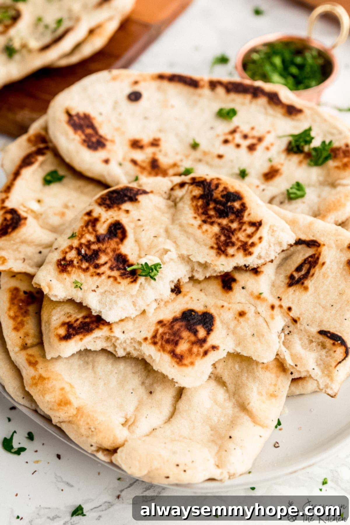 Delicious Homemade Vegan Naan 11 Torn pieces of freshly cooked vegan naan, showing its soft interior.
