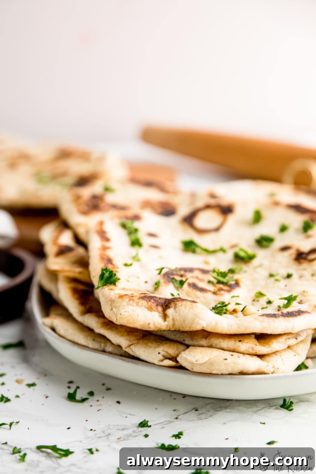 Delicious Homemade Vegan Naan 12 A pile of freshly made vegan naan on a plate, ready for serving.