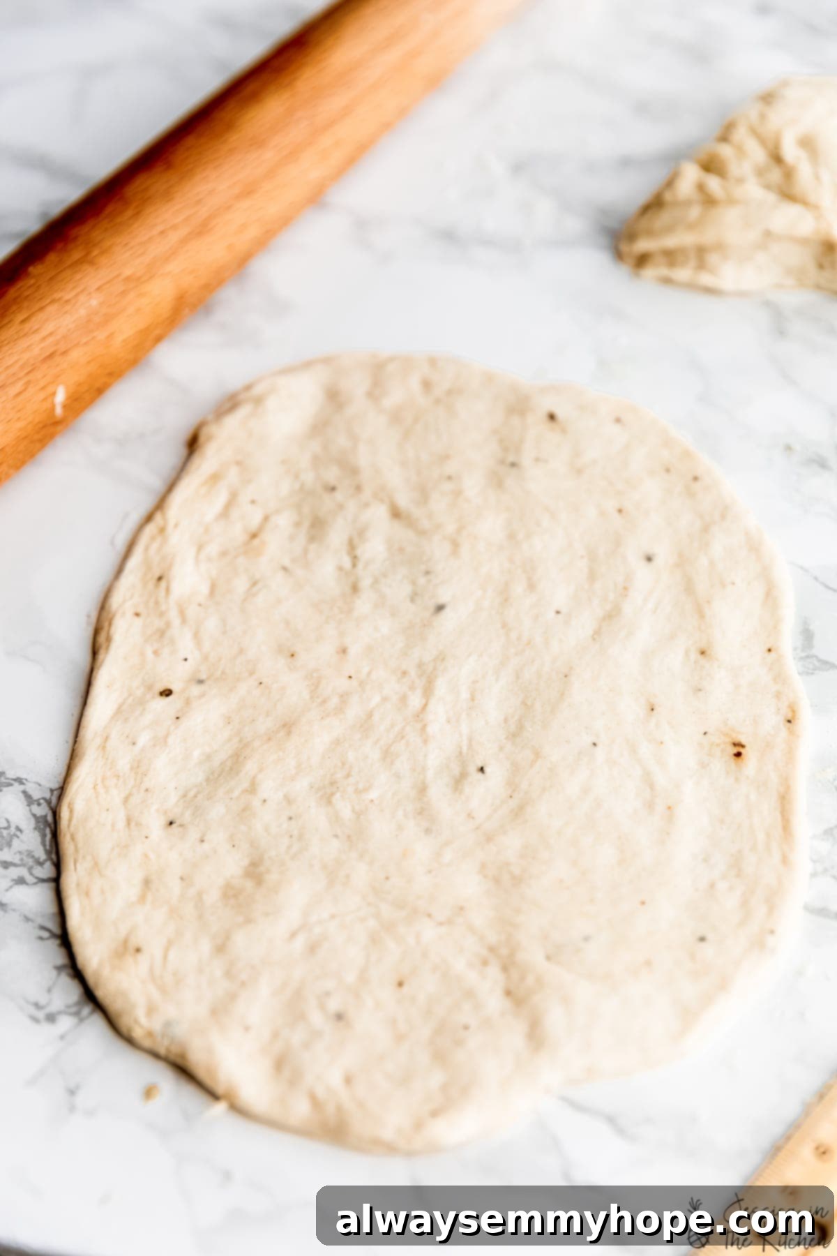 Delicious Homemade Vegan Naan 9 Rolled out vegan naan dough on a countertop, ready for cooking.