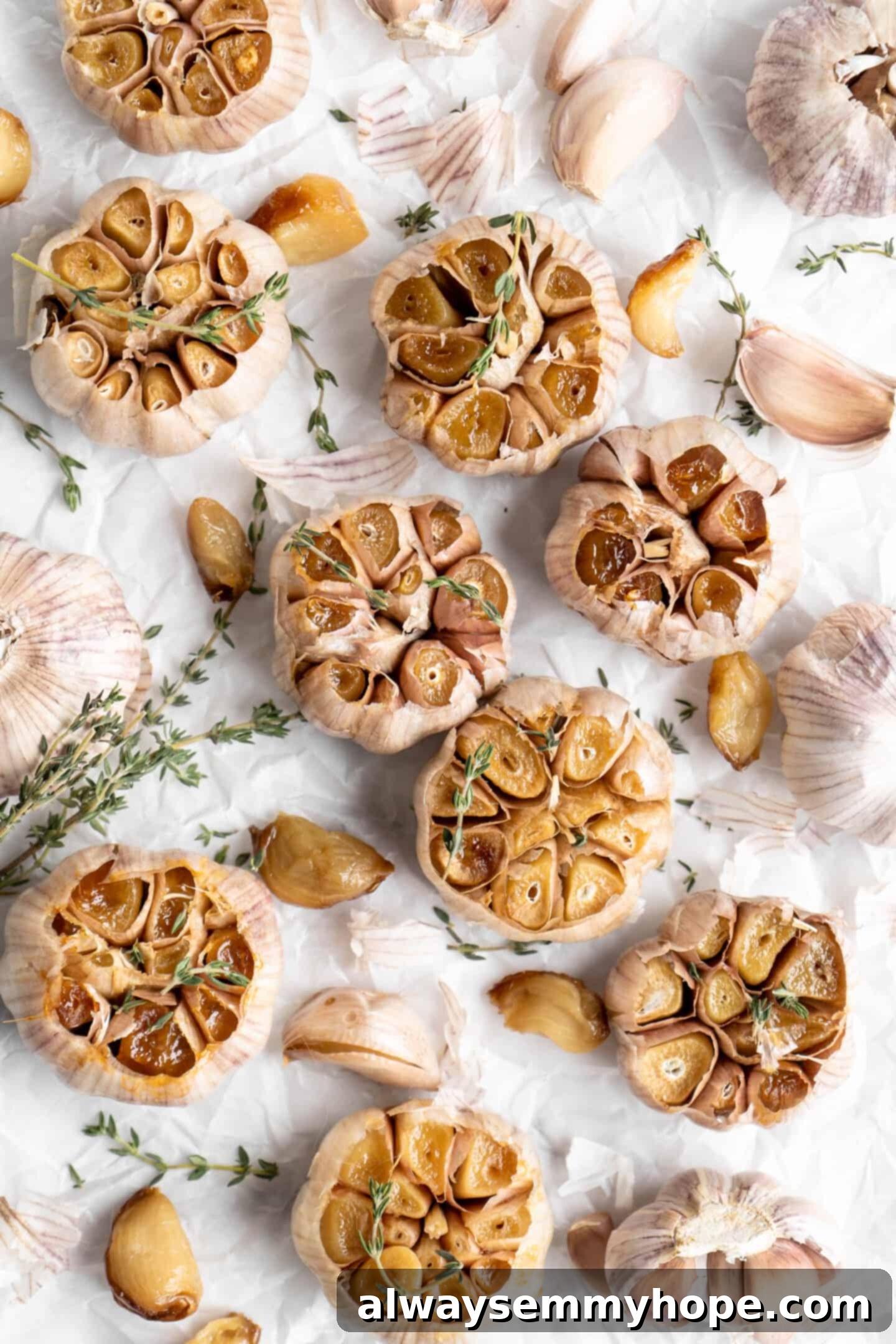 Whole roasted garlic heads and cloves with sprigs of thyme