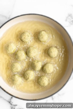 This homemade falafel recipe is just like the kind they make at restaurants. Fluffy on the inside, crispy on the outside, and so delicious! Falafel placed in Dutch oven with oil