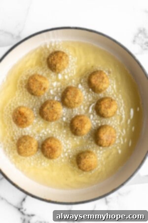 This homemade falafel recipe is just like the kind they make at restaurants. Fluffy on the inside, crispy on the outside, and so delicious! Falafel frying in oil