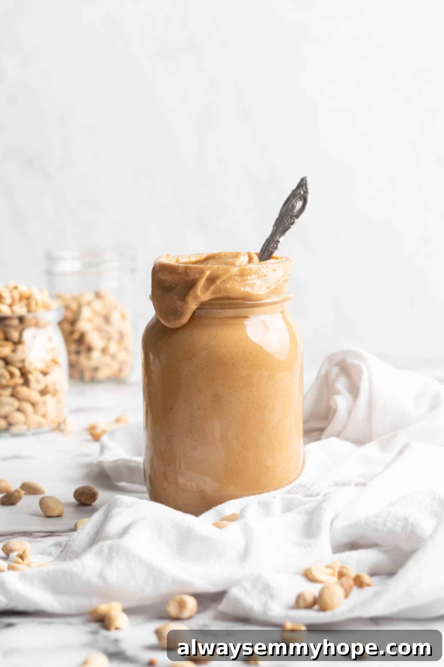 Jar of homemade peanut butter with spoon inside