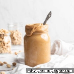 Jar of homemade peanut butter with spoon inside