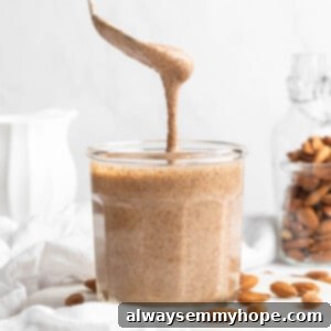 Spoon drizzling almond butter into jar