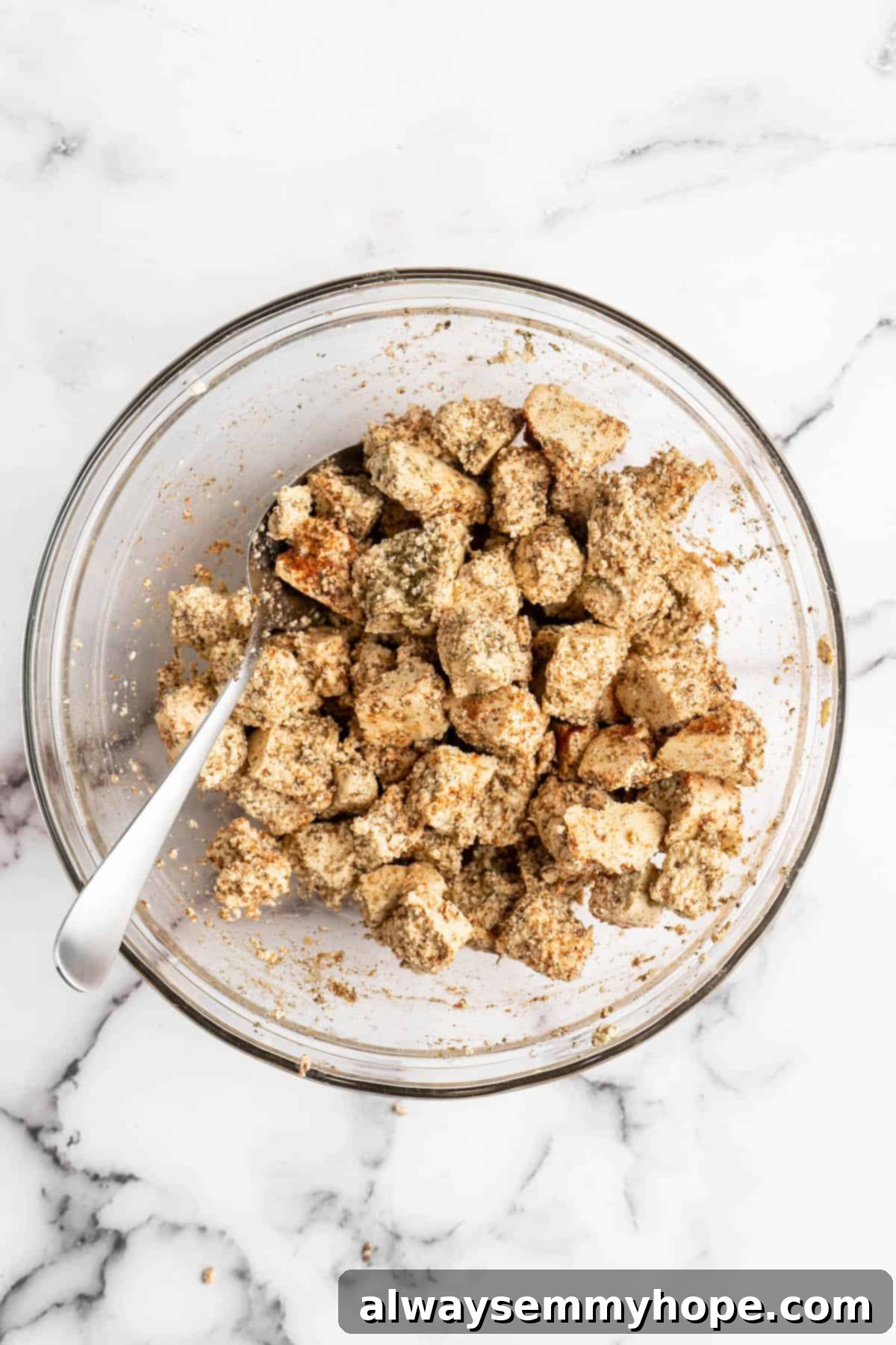 This Jamaican jerk tofu is the real deal! It's spicy, saucy, and just a little bit sweet. It's also super easy to make for a weeknight meal! Overhead view of marinated tofu in glass bowl