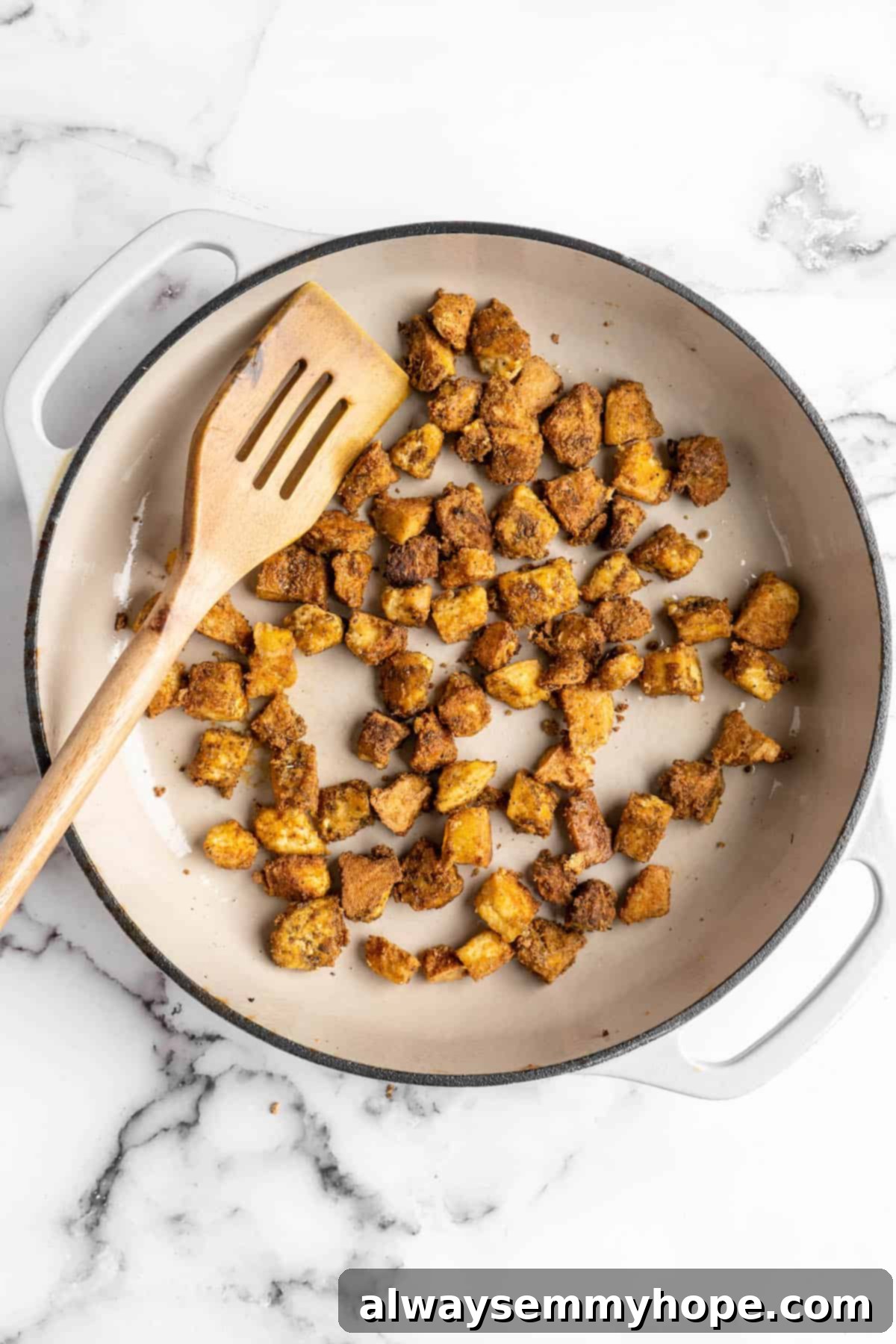 This Jamaican jerk tofu is the real deal! It's spicy, saucy, and just a little bit sweet. It's also super easy to make for a weeknight meal! Overhead view of tofu being cooked in skillet