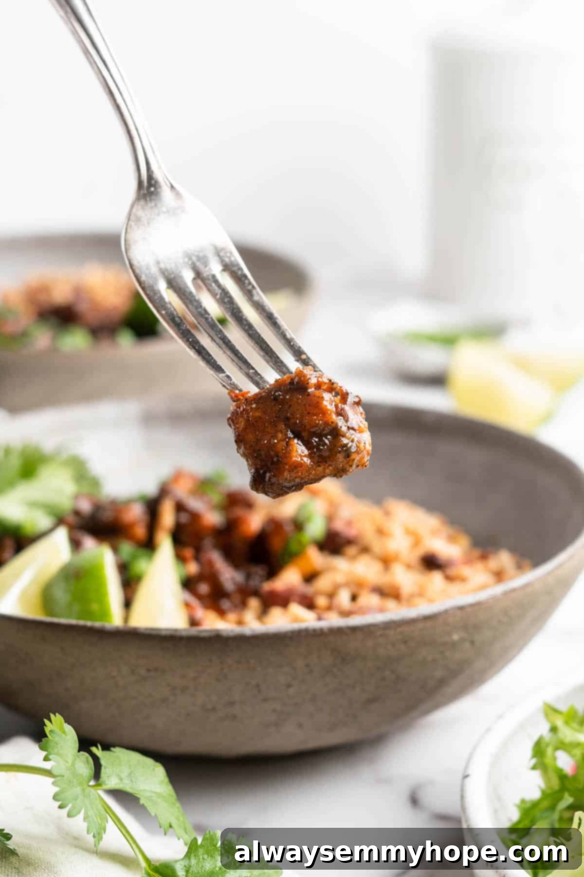 This Jamaican jerk tofu is the real deal! It's spicy, saucy, and just a little bit sweet. It's also super easy to make for a weeknight meal! Piece of Jamaican jerk tofu on fork