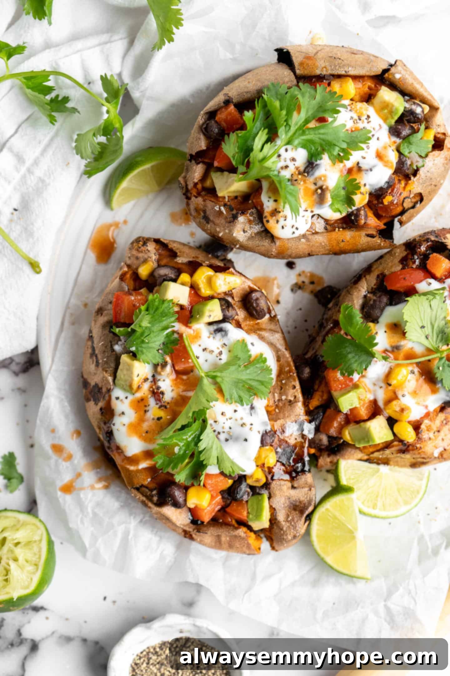 Overhead view of loaded air fryer sweet potatoes on a plate with lime wedges.