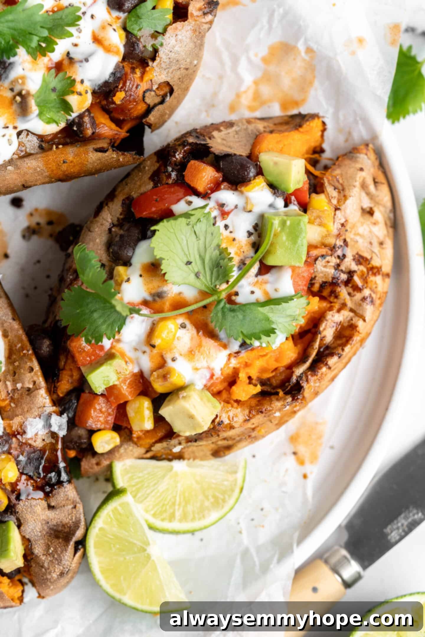 Loaded air fryer sweet potatoes on a plate with lime wedges.