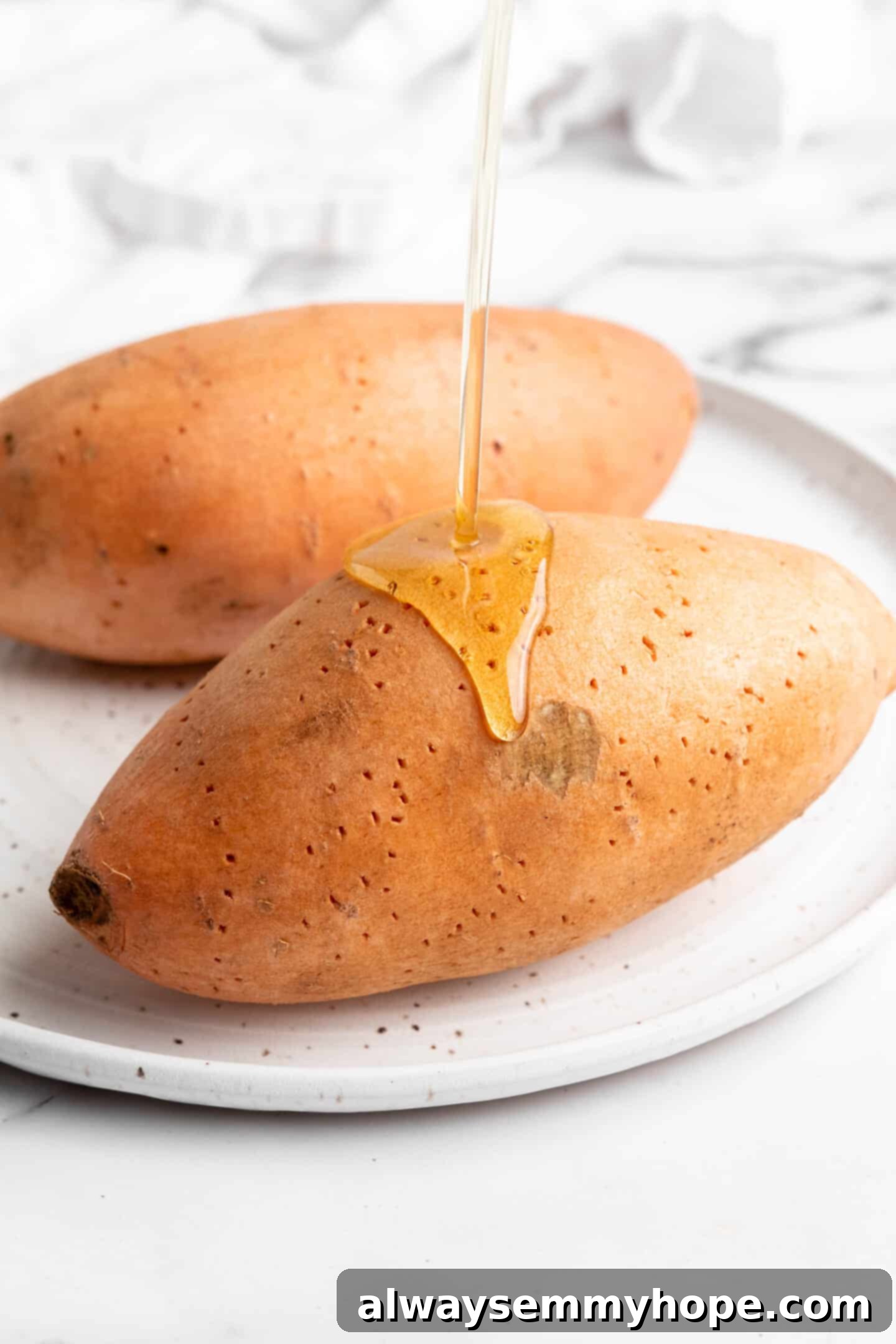 Pouring oil onto a sweet potato.