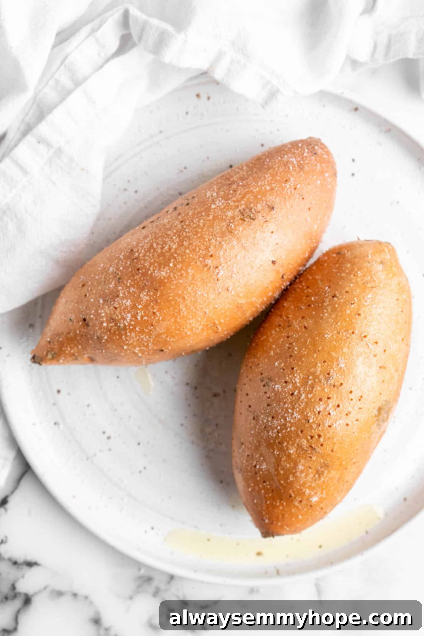 Two sweet potatoes rubbed with oil and salt.