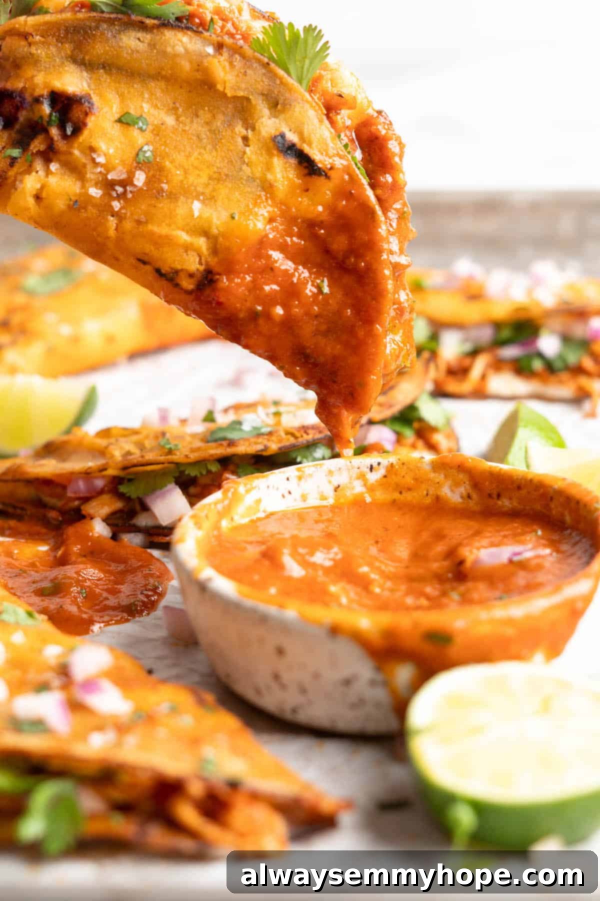 Vegan birria tacos use king oyster mushrooms to mimic the texture/flavour of the original. They’re smoky, crispy, and perfect for dipping! Dipping a vegan birria taco into the sauce.