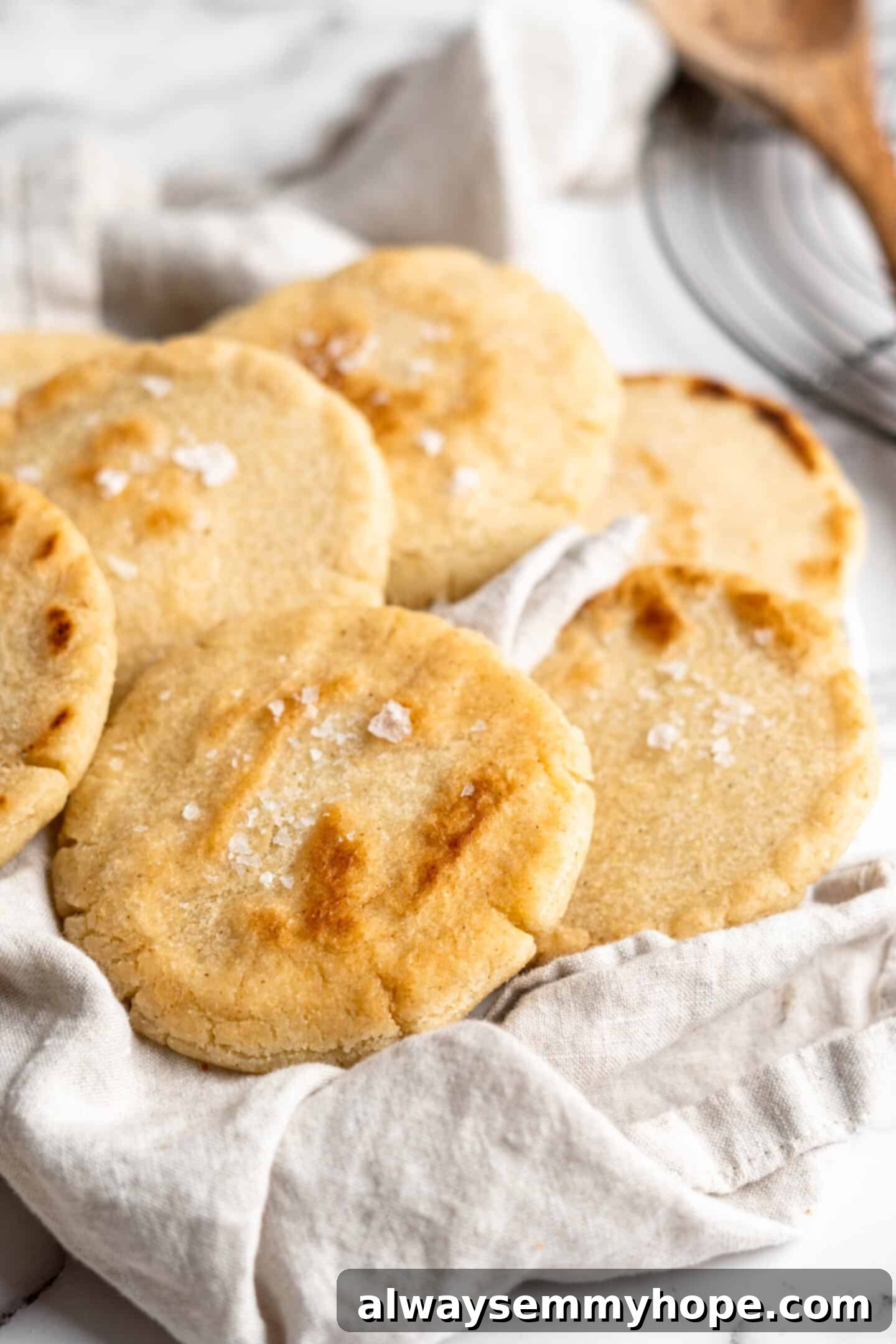 This step-by-step tutorial will show you how to make perfect vegan arepas with just a few ingredients. They're easier to make than you think! Perfectly cooked vegan arepas resting on a patterned tea towel, ready to be enjoyed.