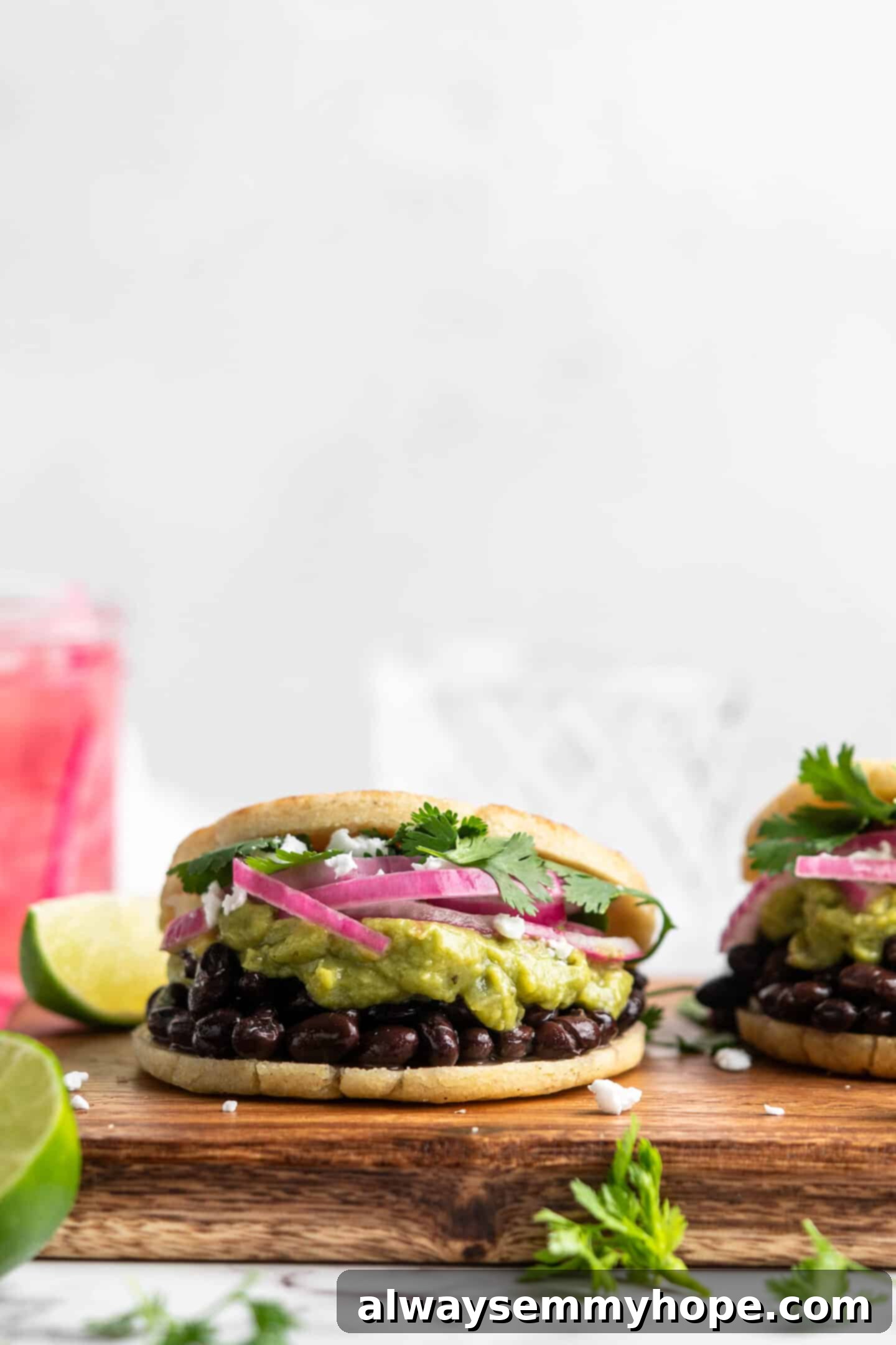 This step-by-step tutorial will show you how to make perfect vegan arepas with just a few ingredients. They're easier to make than you think! Two freshly baked vegan arepas, sliced open and filled with delicious toppings, presented on a rustic cutting board.