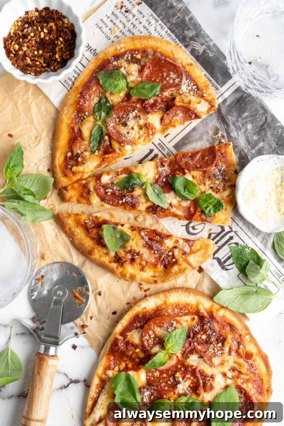 Overhead view of two vegan naan pizzas on a wooden board, one whole and one perfectly sliced, ready to be enjoyed.