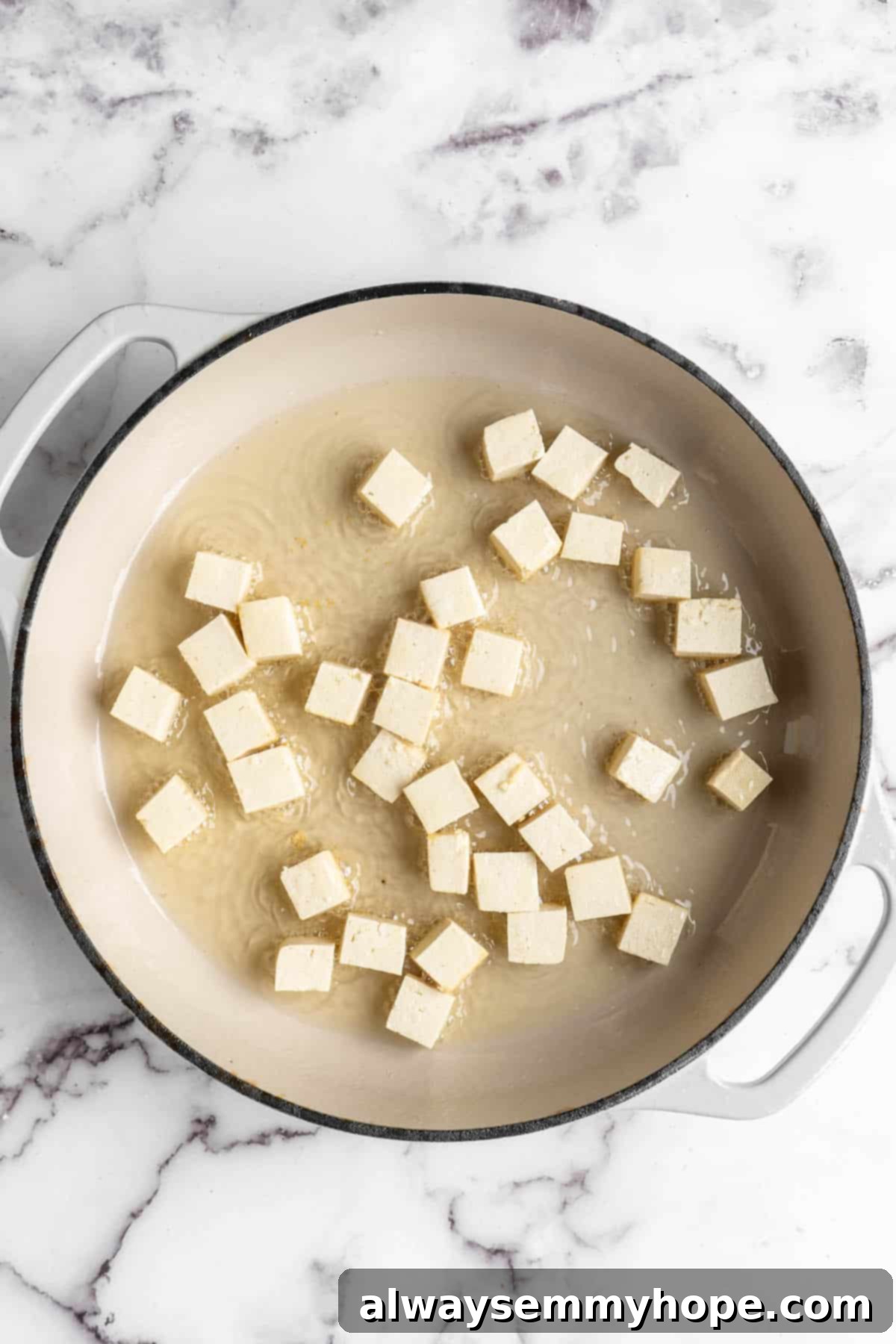 Overhead view of tofu cubes after adding to skillet