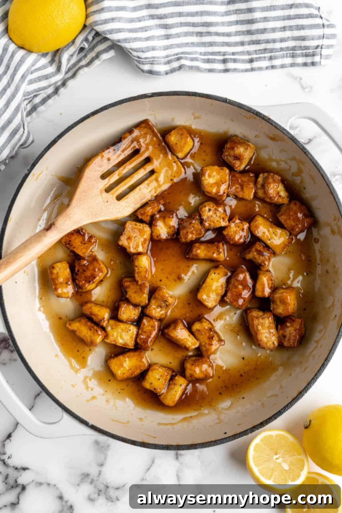 This lemon pepper tofu is crispy and saucy, with the perfect chewy texture. It takes minutes to make and it's absolutely packed with flavour! Overhead view of lemon pepper tofu in a skillet.
