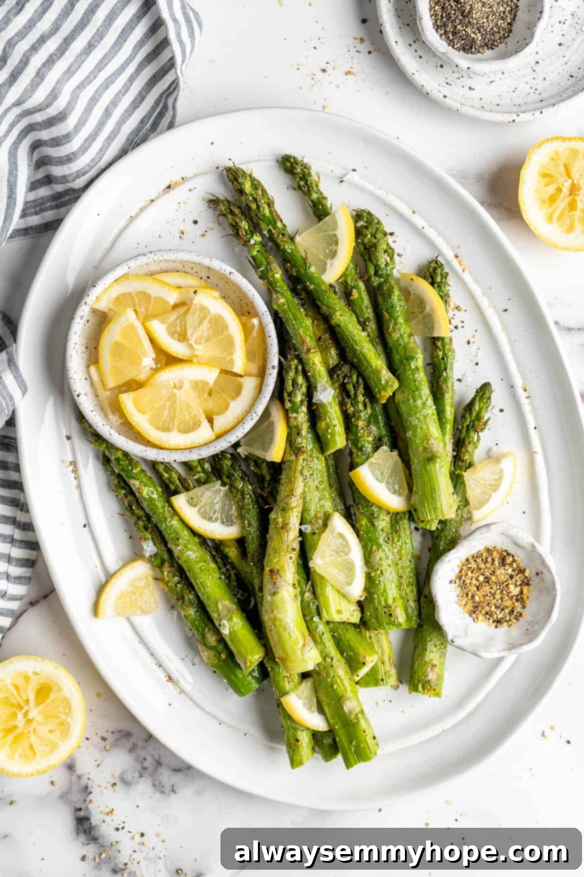 This easy lemon pepper air fryer asparagus is the perfect side dish for busy weeknights. It's done in just 10 minutes from start to finish! A vibrant platter of freshly cooked lemon pepper air fryer asparagus, garnished with fresh lemon wedges, ready to serve.