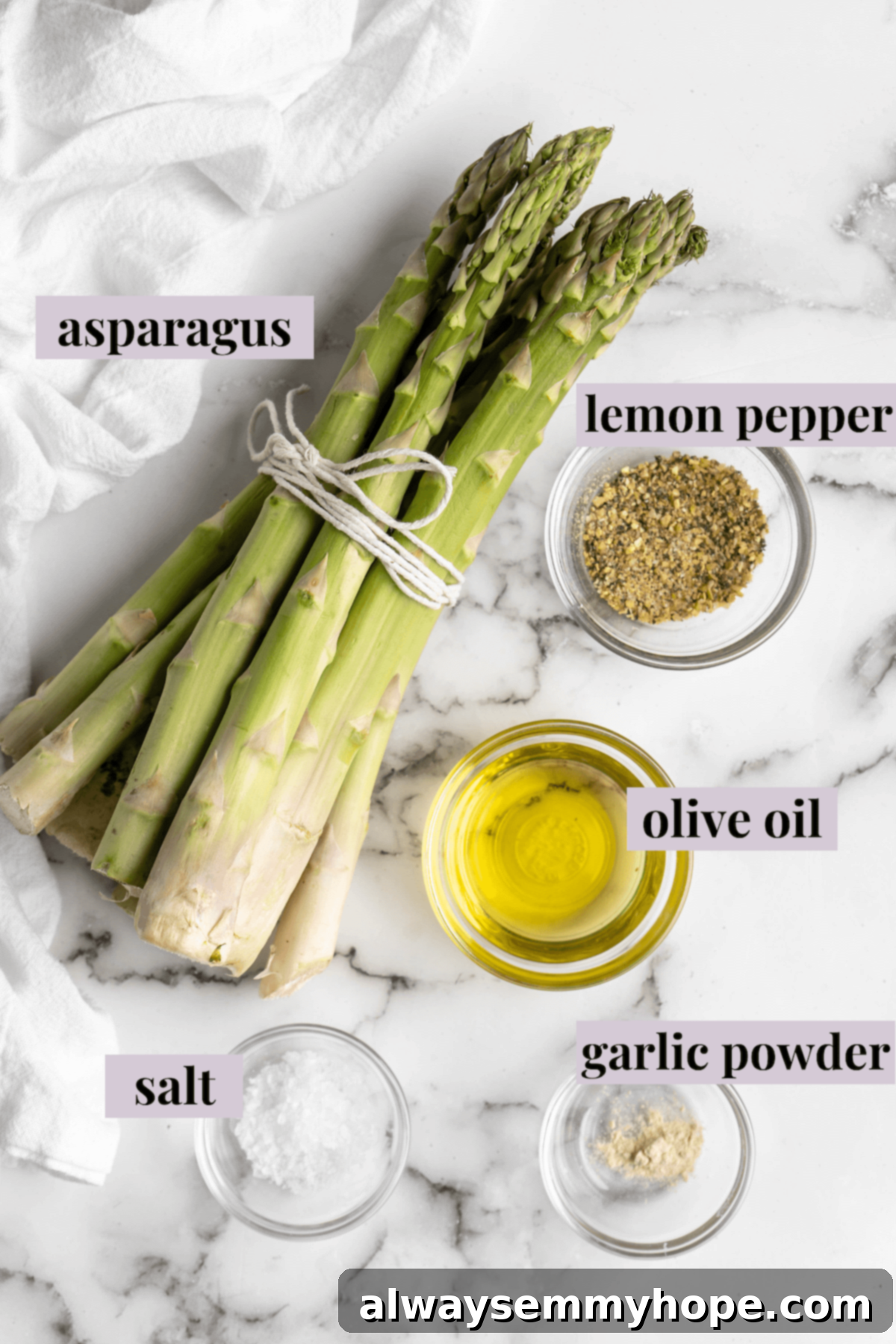 This easy lemon pepper air fryer asparagus is the perfect side dish for busy weeknights. It's done in just 10 minutes from start to finish! Overhead view of fresh asparagus, olive oil, lemon pepper seasoning, garlic powder, and sea salt, laid out as ingredients for air fryer asparagus.