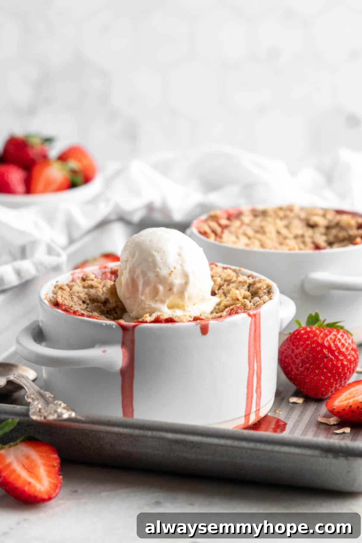 This vegan strawberry crumble is easy as can be! You only need 5 ingredients and a few minutes of assembly for the perfect summer dessert. Strawberry crumble topped with scoop of vanilla ice cream