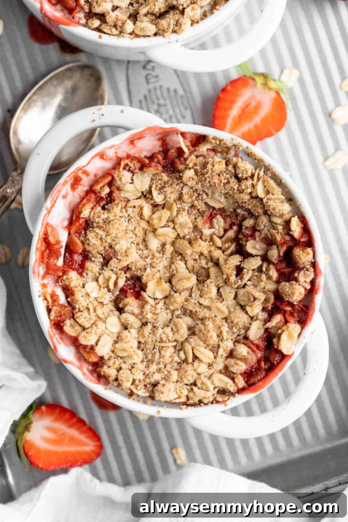 This vegan strawberry crumble is easy as can be! You only need 5 ingredients and a few minutes of assembly for the perfect summer dessert. Overhead view of strawberry crumble in ramekin